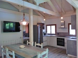 a kitchen with a wooden table and a kitchen with a refrigerator at Casa Nadia in Ledro