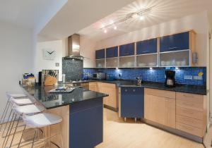 uma grande cozinha com armários azuis e uma bancada em The York Place Residence em Edimburgo