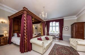 a bedroom with a bed and a couch and a table at Goldsborough Hall in Knaresborough