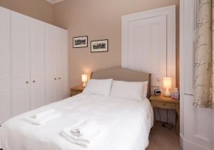 a bedroom with a white bed with two night stands at The Coates Gardens Residence in Edinburgh