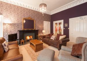 a living room with a couch and a fireplace at The Coates Gardens Residence in Edinburgh