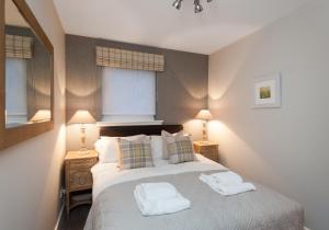 um quarto com uma cama com duas toalhas em The Botanist Apartment Edinburgh Old Town 2 Bedroom Lift Parking previously The Parkgate Residence em Edinburgo