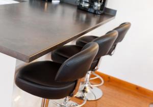 a row of black bar stools under a counter at The Traquair Park Residence in Edinburgh