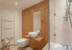 uma casa de banho com um lavatório, um WC e um chuveiro em The Quartermile Meadows View Residence em Edimburgo