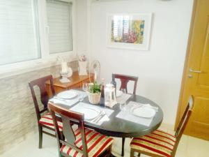 - une table à manger avec 4 chaises, une table, une table et des chaises dans l'établissement Apartment Rita, à Ston