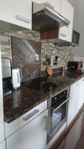 a kitchen with a stove and a counter top at Klimatisiertes Ferienapartment an der Stadtgrenze von Berlin in Gosen