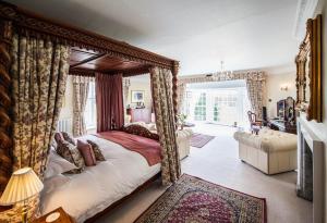 a bedroom with a canopy bed and a living room at Goldsborough Hall in Knaresborough