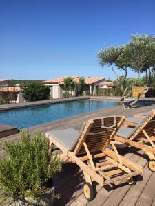 a pair of lounge chairs next to a swimming pool at Villa Madra in Bonifacio