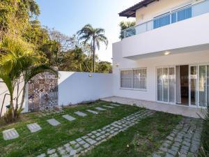 una casa blanca con un jardín delante de ella en Aluguel Casa 3 quartos p/ 12 pessoas | Bombas/SC, en Bombinhas