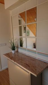 a kitchen with a counter with a mirror at Klimatisiertes Ferienapartment an der Stadtgrenze von Berlin in Gosen