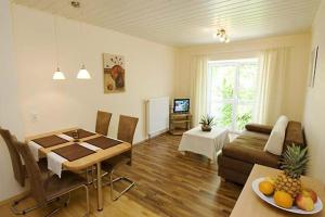 uma sala de estar com uma mesa e um sofá em Apartments Herrlichkeit Dornum em Dornum