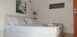 a bed with white sheets and pillows in a room at Marina's Rooms in Larnaca