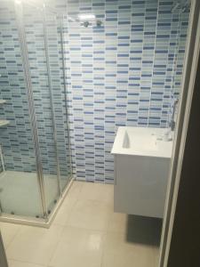 een witte badkamer met een douche en een wastafel bij La Casa de Las Flores in Mairena del Aljarafe