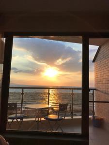 a view of the sunset from a balcony with a table and chairs at Elizabeth' Luxury Apartments in Pomorie