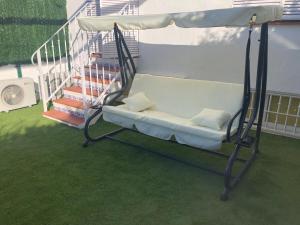 a swinging bed on a balcony with a staircase at La Casa de Las Flores in Mairena del Aljarafe