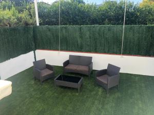 three chairs and a coffee table on a patio at La Casa de Las Flores in Mairena del Aljarafe +7 photos