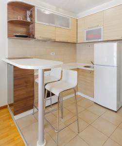 een keuken met een witte tafel en 2 witte stoelen bij Zebra in Podgorica
