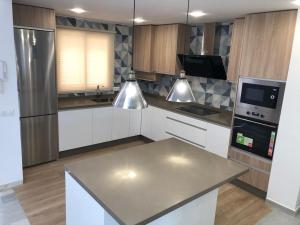 a kitchen with white cabinets and a stainless steel appliance at La Casa de Las Flores in Mairena del Aljarafe