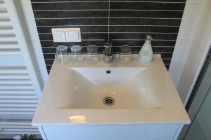 a bathroom sink with glasses and a bottle on it at Chaletpark Petzen in Feistritz ob Bleiburg +44 photos
