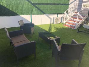 a group of chairs and a table on a lawn at La Casa de Las Flores in Mairena del Aljarafe