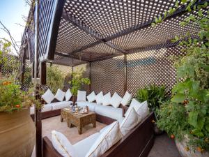 um pátio exterior com sofás brancos e uma mesa em Riad Il Parco dei Principi em Marrakech