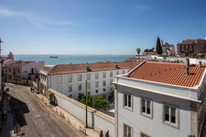 uma vista para uma rua da cidade com edifícios e o oceano em Alfama River View Tailor Made Flat em Lisboa