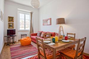 uma sala de estar com uma mesa e um sofá em Alfama River View Tailor Made Flat em Lisboa