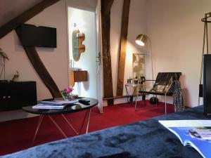 een kamer met een bed, een tafel en een tv bij La Levraudière in Cheverny