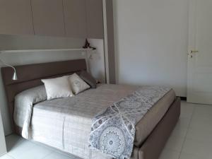 una camera da letto con un grande letto con lenzuola bianche di APPARTAMENTO nonni FRANCHI a Loano