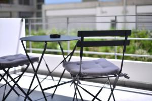 two chairs and a table on a balcony at Soho Apartments by Olala Homes in Athens
