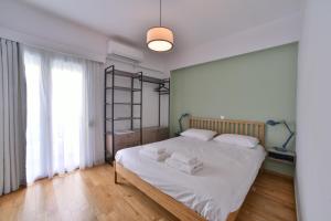 a bedroom with a bed with white sheets and white pillows at Soho Apartments by Olala Homes in Athens