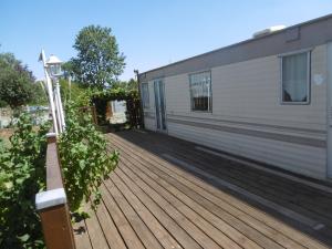 a wooden deck next to a building at nature et repos in Sanghen