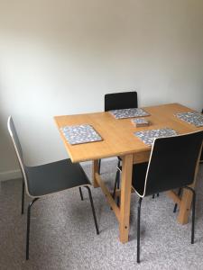 uma mesa de madeira com quatro cadeiras num quarto em 8 Pickering Road em Telford