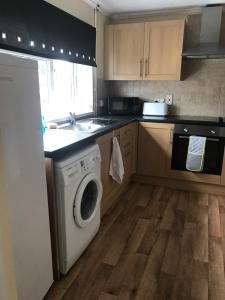 a kitchen with a washing machine and a sink at 8 Pickering Road in Telford