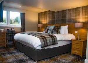 
a bedroom with a bed and a dresser at McKays Hotel in Pitlochry
