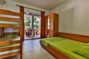 a bedroom with two bunk beds and a balcony at Apartments Venezia in Sutomore