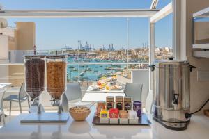 een keuken met een tafel met eten en een blender bij Dun Gorg Guest House in Marsaxlokk