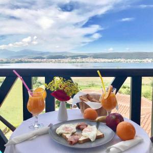 einen Tisch mit einem Teller mit Speisen und Getränken auf dem Balkon in der Unterkunft La Suite Boutique Hotel & Spa in Ioannina