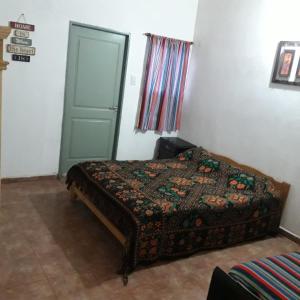 Un dormitorio con una cama y una puerta verde. en Departamentos ramallo, en Ramallo