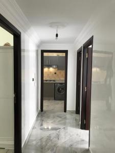 Tetouan Relax Apartement في تطوان: ممر مع مرآة في غرفة بيضاء +37 صورة