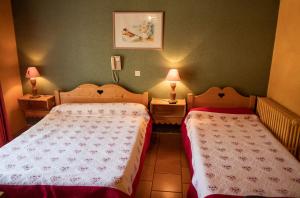 twee bedden in een kleine kamer met twee lampen bij Hotel Relais Saint Louis in Saint-Martin-Vésubie