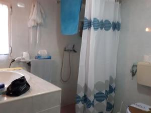 a bathroom with a shower curtain and a sink at Villino Dodò in Torre San Giovanni Ugento