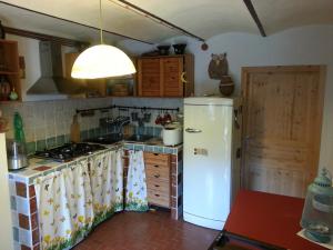 cocina con nevera blanca y fogones en La casa sull'arcobaleno en Manta