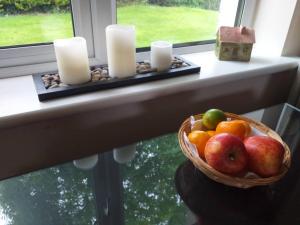 a basket of fruit sitting on a window sill with candles at Nick & Sandra's in Slane