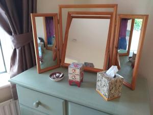 a dresser with two mirrors and a box on it at Nick & Sandra's in Slane