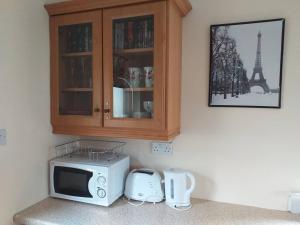 a microwave in a kitchen with a cabinet and the eiffel tower at Nick & Sandra's in Slane