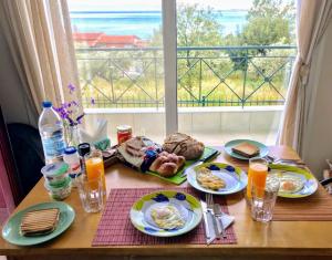 una mesa con platos de desayuno y una ventana en SEMIRAMIS SUITES with pool and private jacuzzi, en Kalamata