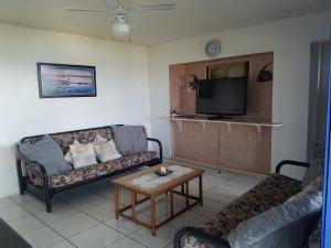 a living room with two couches and a tv at The Seaside in Scottburgh
