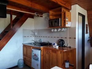 a small kitchen with a sink and a stove at La Ñata in Tornquist
