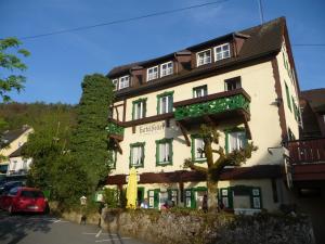 ein Gebäude mit einem roten Auto, das davor geparkt ist in der Unterkunft Hotel Feiler in Muggendorf